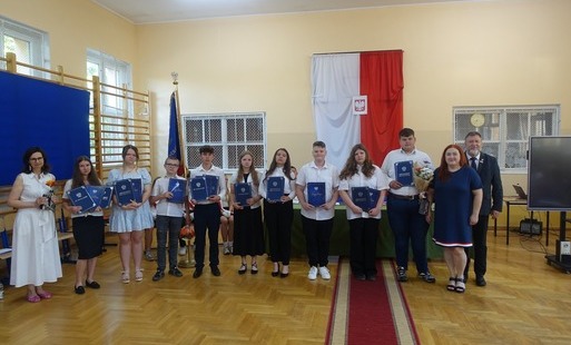 Absolwenci trzy,mający w rękach świadectwa ukończenia szkoły wraz z Panią Dyrektor, wychowawczynią i Panem Burmistrzem 